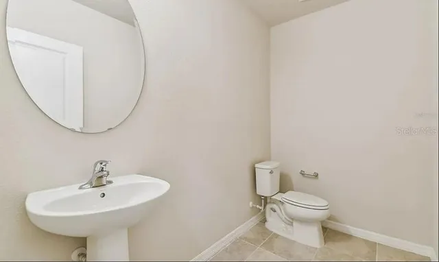 a white toilet sitting next to a bathroom sink