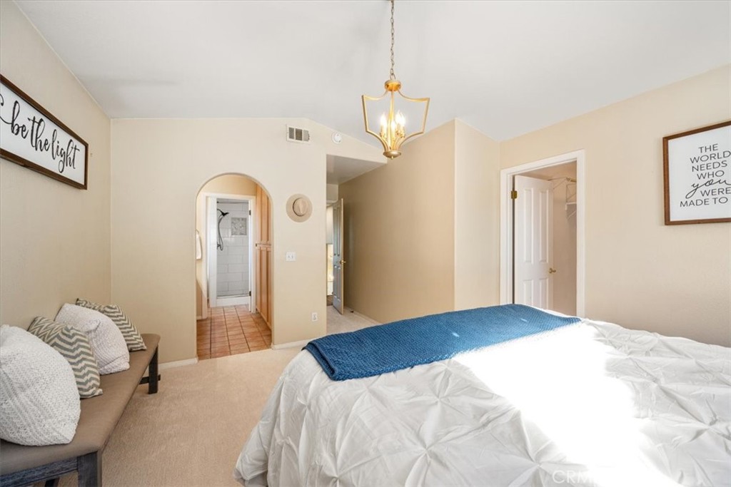 1306 Avenida Pelicanos Oceano, CA 93445 - Photo 13 of 39 a bedroom with a bed and a chandelier