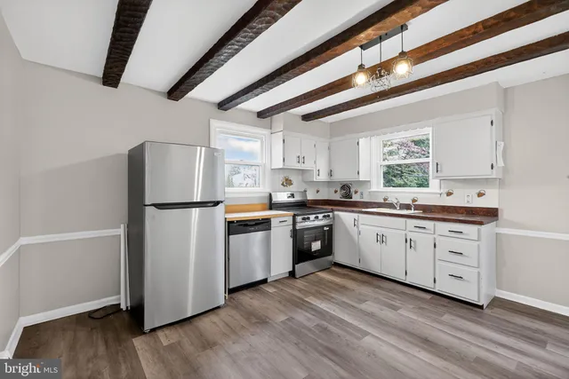 a kitchen with sink refrigerator and cabinets
