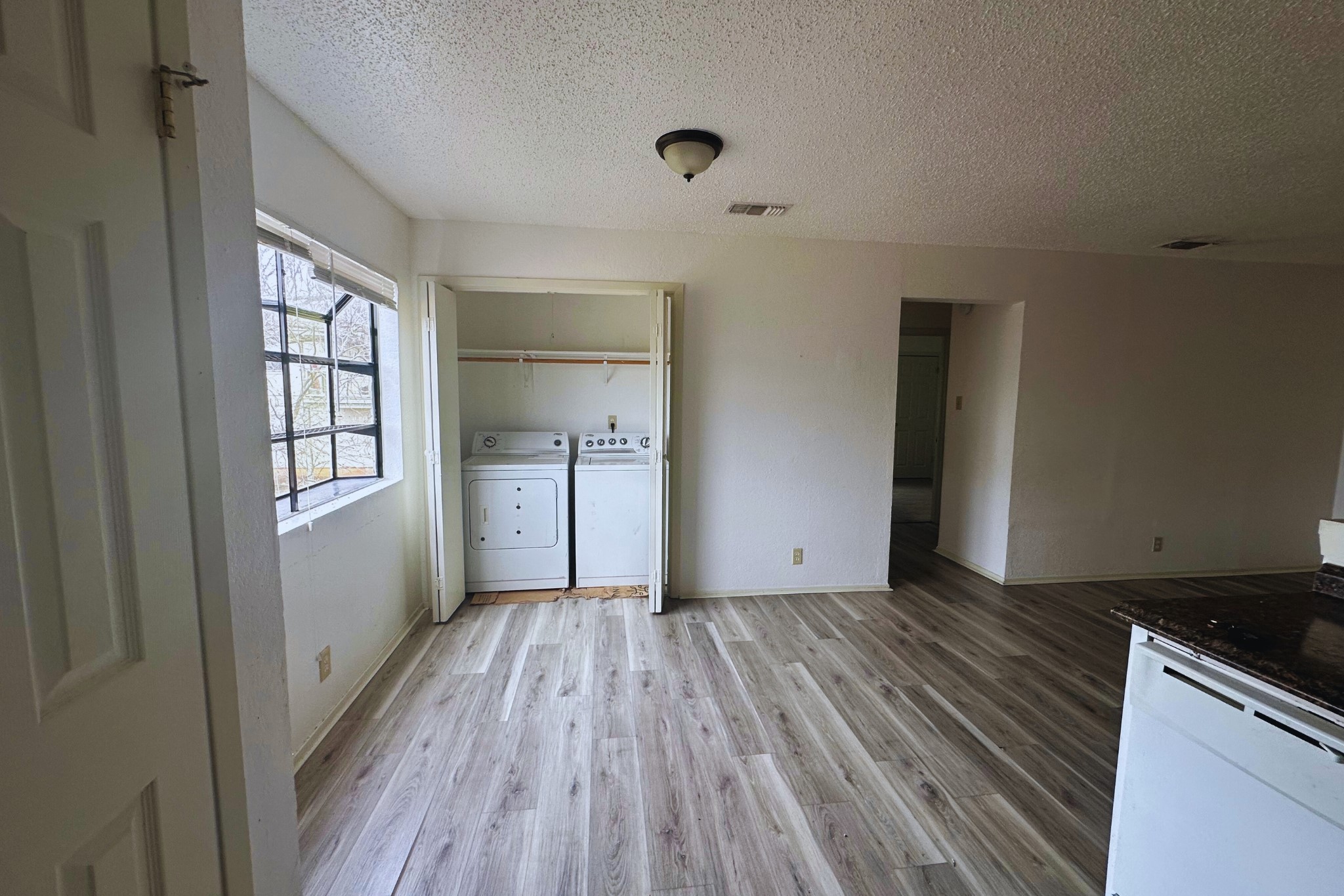 2202 Tabor Court, Unit C Austin, TX 78748 - Photo 7 of 14 Laundry room with light wood-style floors, washer and dryer, and a textured ceiling