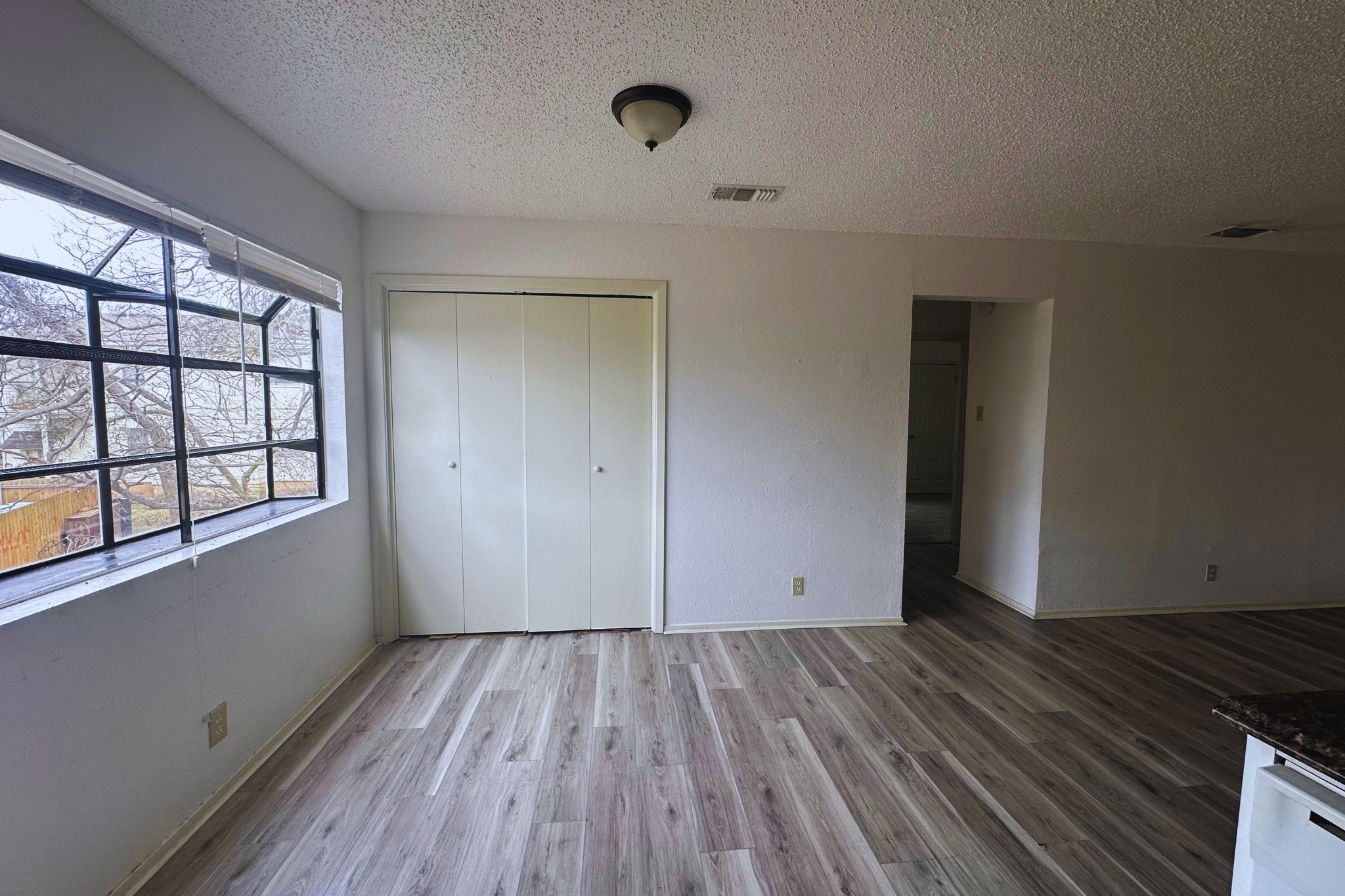 2202 Tabor Court, Unit C Austin, TX 78748 - Photo 8 of 14 Unfurnished bedroom featuring light wood-type flooring, a textured ceiling, and a closet