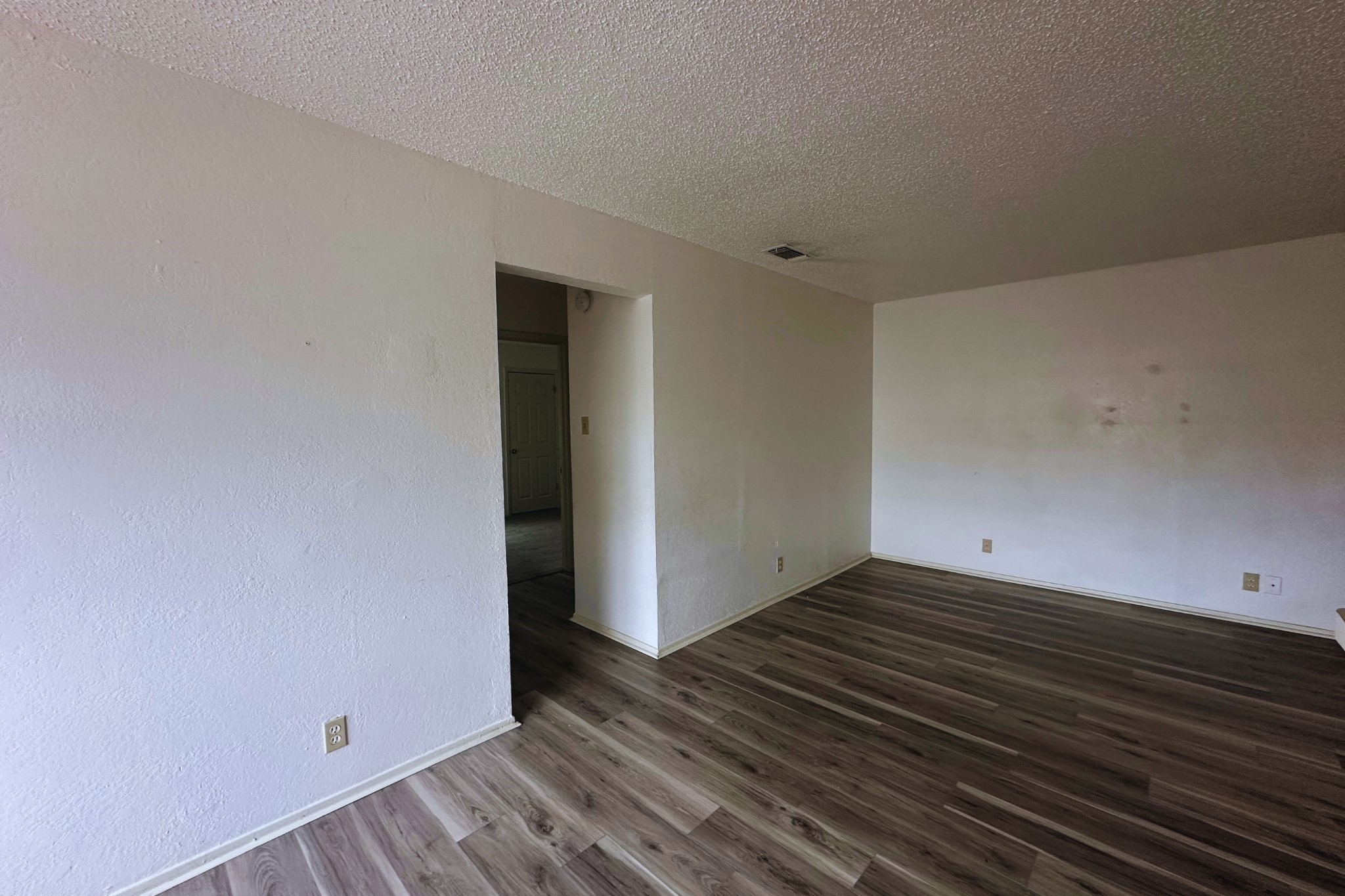 2202 Tabor Court, Unit C Austin, TX 78748 - Photo 9 of 14 Unfurnished room featuring a textured ceiling and dark wood-type flooring