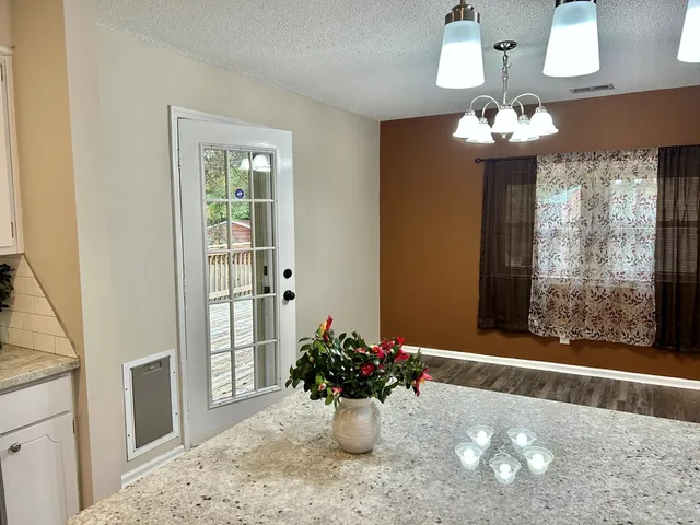 a kitchen with stainless steel appliances white cabinets a window and a sink