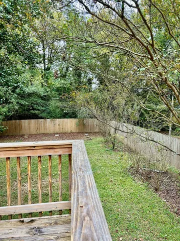 a view of small backyard with small cabin and wooden fence