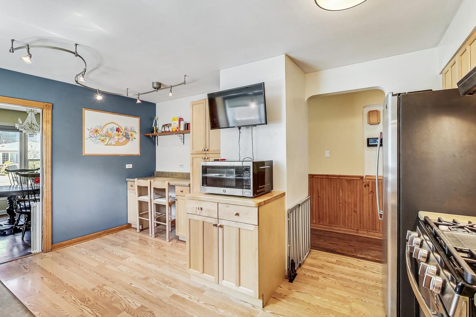 3312 Crain Street Skokie, IL 60076 - Photo 11 of 34 a kitchen with a stove a refrigerator and a stove top oven with wooden floor
