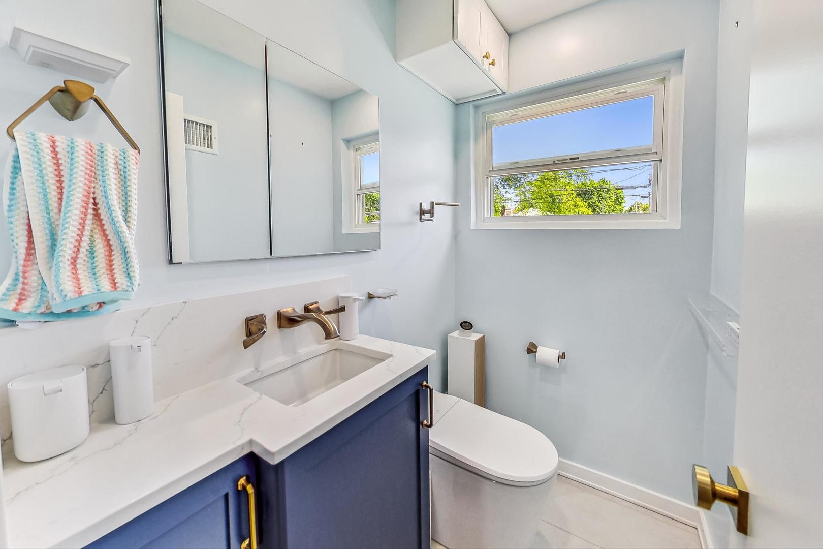3312 Crain Street Skokie, IL 60076 - Photo 13 of 34 a bathroom with a sink toilet and mirror