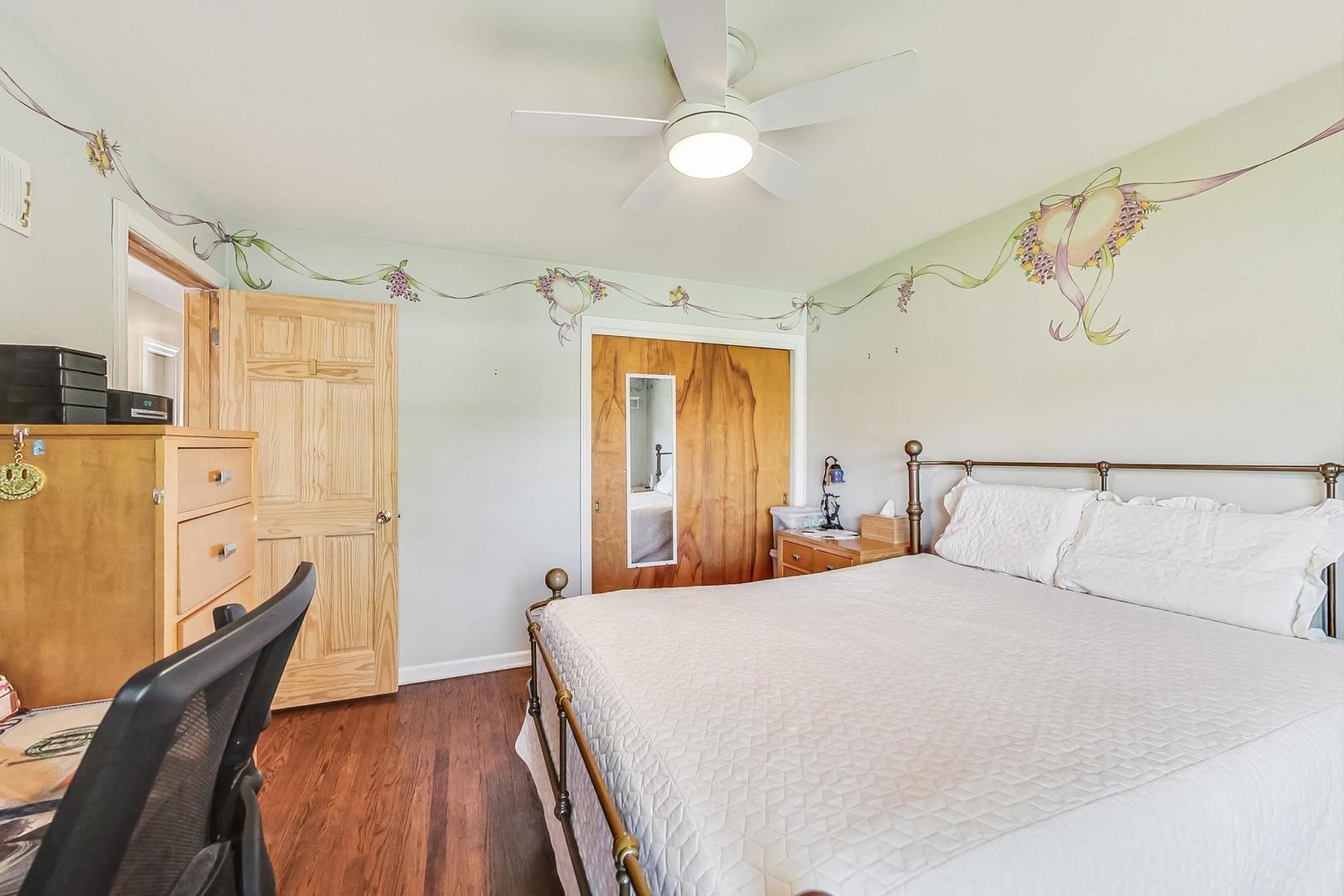 3312 Crain Street Skokie, IL 60076 - Photo 16 of 34 a bedroom with a large bed and a chandelier