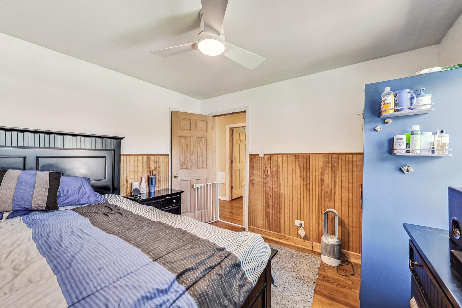 3312 Crain Street Skokie, IL 60076 - Photo 18 of 34 a bedroom with a bed and wooden floor