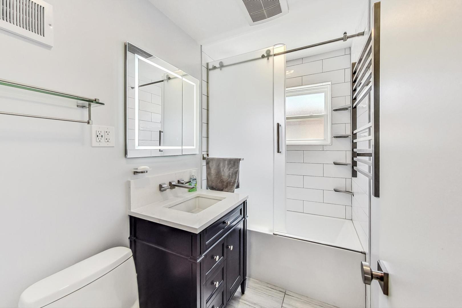 3312 Crain Street Skokie, IL 60076 - Photo 20 of 34 a bathroom with a sink toilet vanity and shower