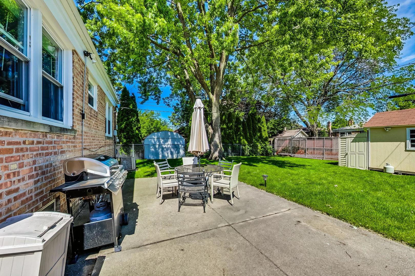 3312 Crain Street Skokie, IL 60076 - Photo 32 of 34 a view of a patio with table and chairs potted plants and a large tree