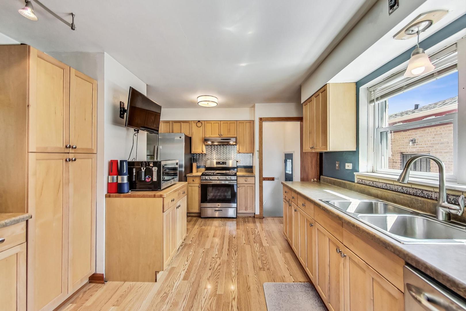 3312 Crain Street Skokie, IL 60076 - Photo 10 of 34 a kitchen with stainless steel appliances a refrigerator sink and cabinets