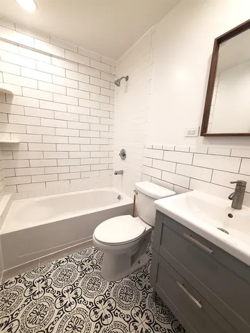 a bathroom with a sink toilet a mirror and bathtub