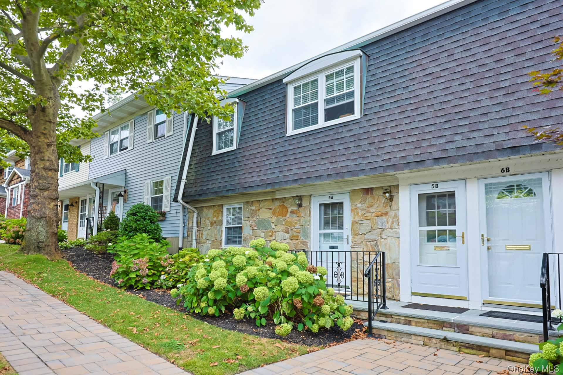 10 Harbour Lane, Unit 5A Oyster Bay, NY 11771 - Photo 20 of 25 Walkway Approach – Side angle revealing the landscaped pathway and attractive curb appeal, emphasizing the home’s quiet setting within the community.