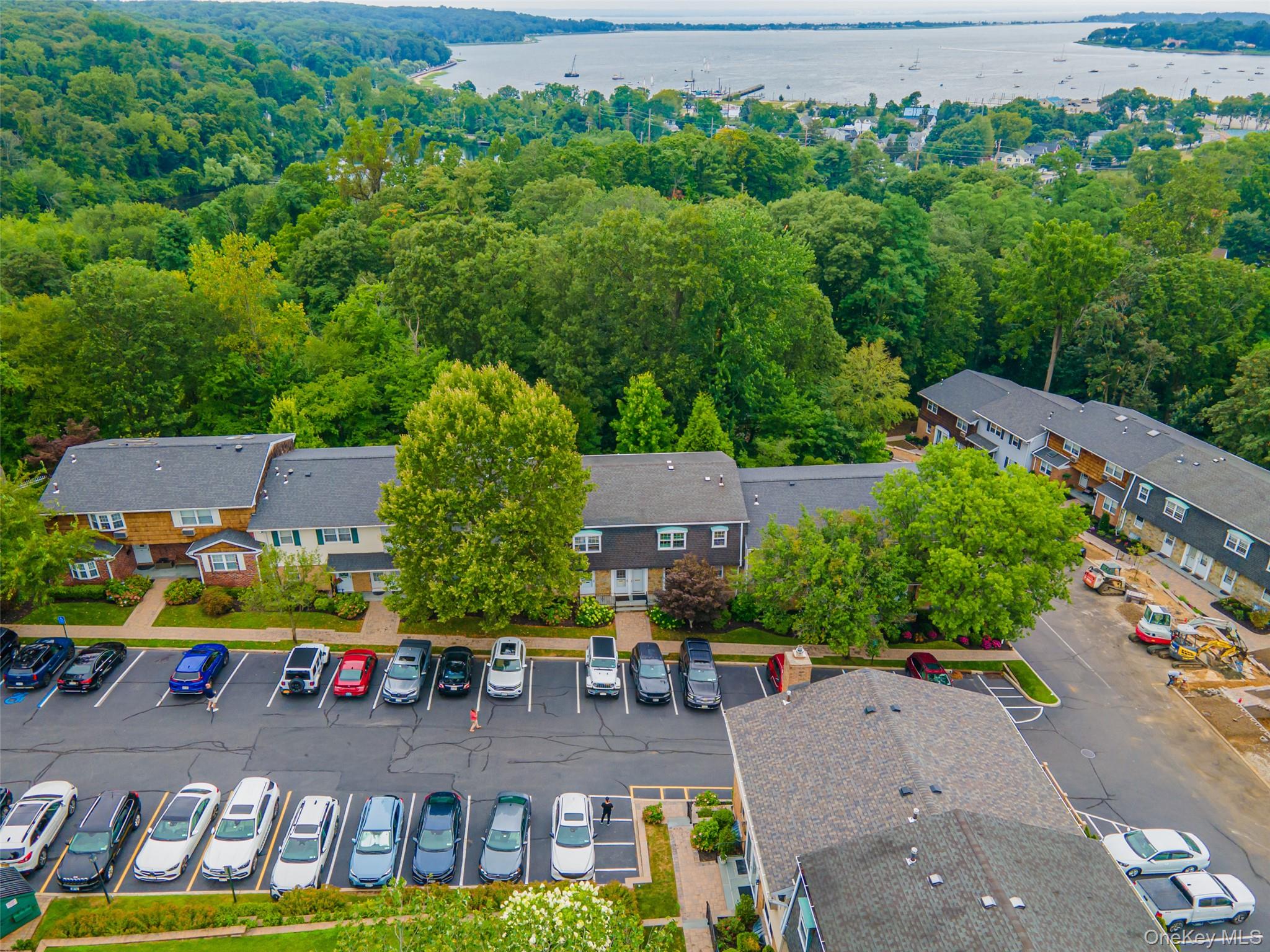 10 Harbour Lane, Unit 5A Oyster Bay, NY 11771 - Photo 21 of 25 Complex and Parking Area – Bird’s-eye perspective displaying the well-kept grounds, parking convenience, and mature landscaping throughout the community.