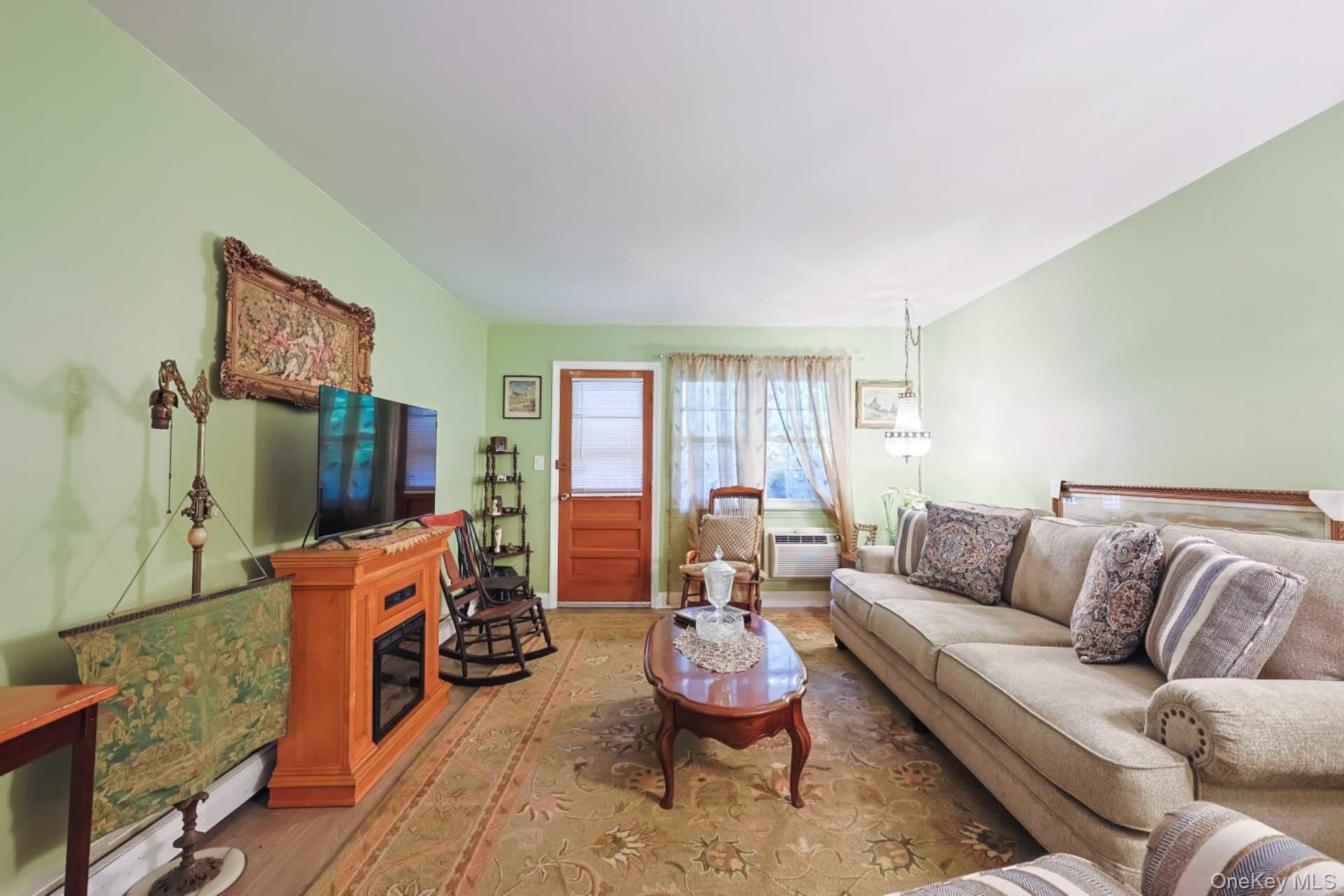 10 Harbour Lane, Unit 5A Oyster Bay, NY 11771 - Photo 3 of 25 Living room – Bright, comfortable space with natural light, neutral tones, and an open layout that flows seamlessly into the dining area.