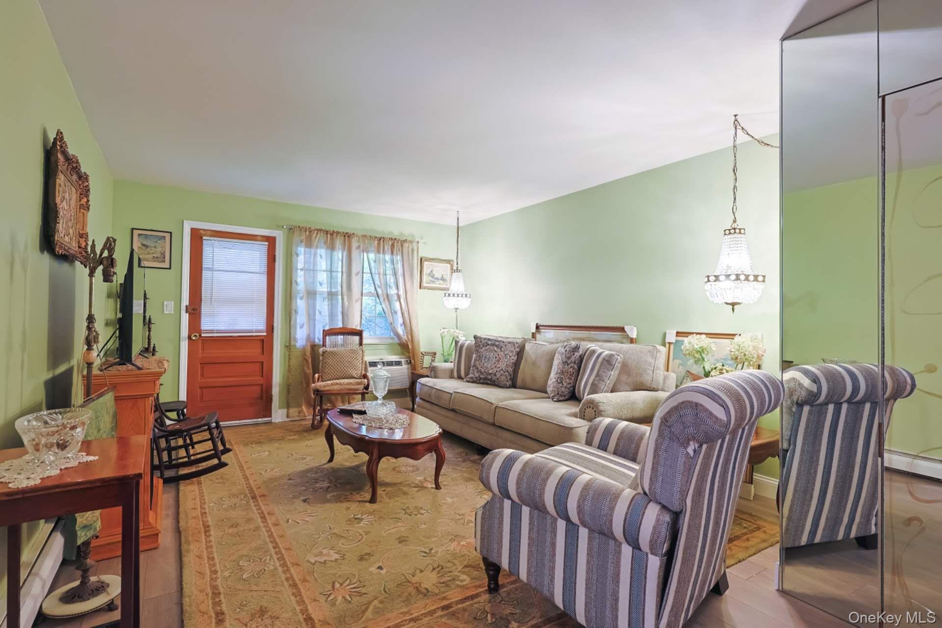 10 Harbour Lane, Unit 5A Oyster Bay, NY 11771 - Photo 4 of 25 Primary Bedroom – Tranquil bedroom retreat with plush carpeting, soft blue walls, and a large window providing plenty of natural light and backyard views.