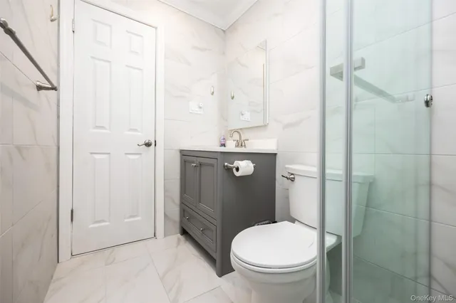 a bathroom with a granite countertop toilet and a sink