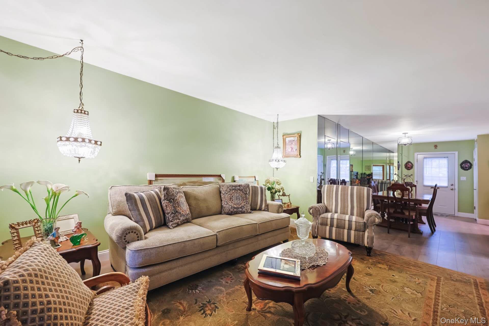 10 Harbour Lane, Unit 5A Oyster Bay, NY 11771 - Photo 9 of 25 Living Room Alternate View – Cozy living space with a charming fireplace feature, ample seating, and front-facing windows that create a welcoming atmosphere.