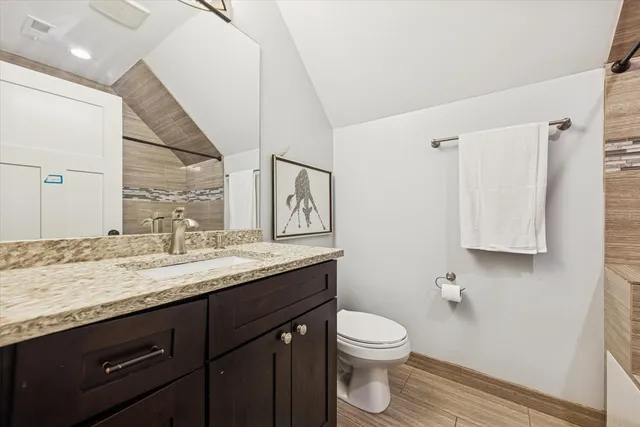 a bathroom with a granite countertop sink a toilet and a mirror
