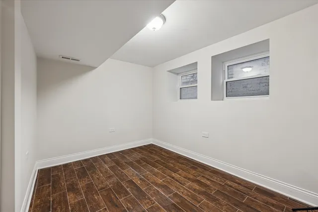 a view of a room with wooden floor and white walls