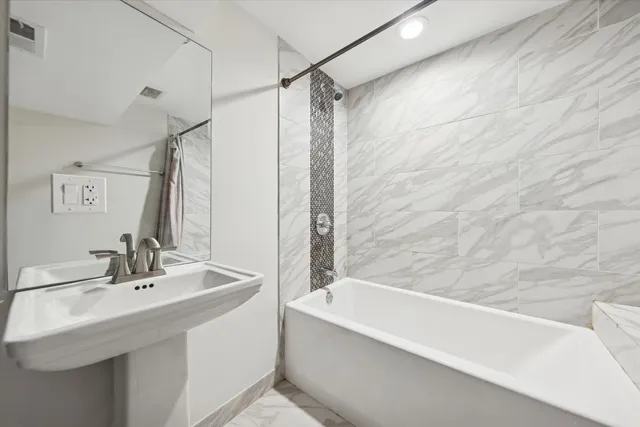 a bathroom with a bathtub and a sink