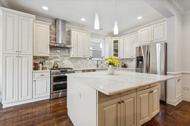 a kitchen with stainless steel appliances granite countertop a refrigerator stove microwave and white cabinets