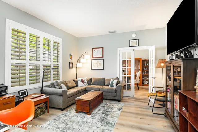 a living room with furniture flat screen tv and a large window