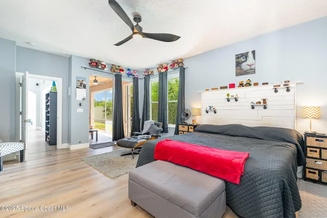 a bedroom with furniture and a large window