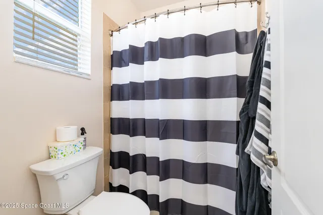 a bathroom with a sink a toilet a shower curtain