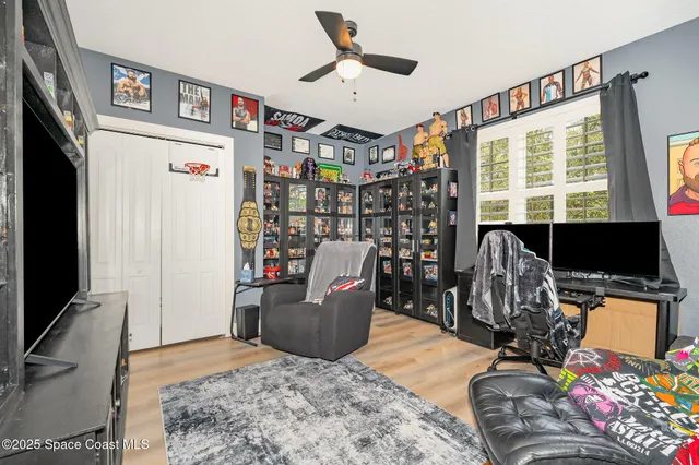 a living room with furniture a flat screen tv and a refrigerator