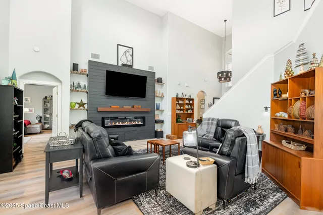 a living room with furniture a flat screen tv and a fireplace