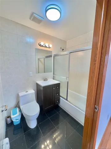a spacious bathroom with a toilet a sink and a mirror