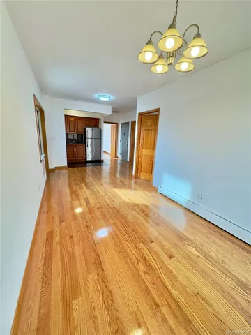 a view of an empty room with a chandelier fan