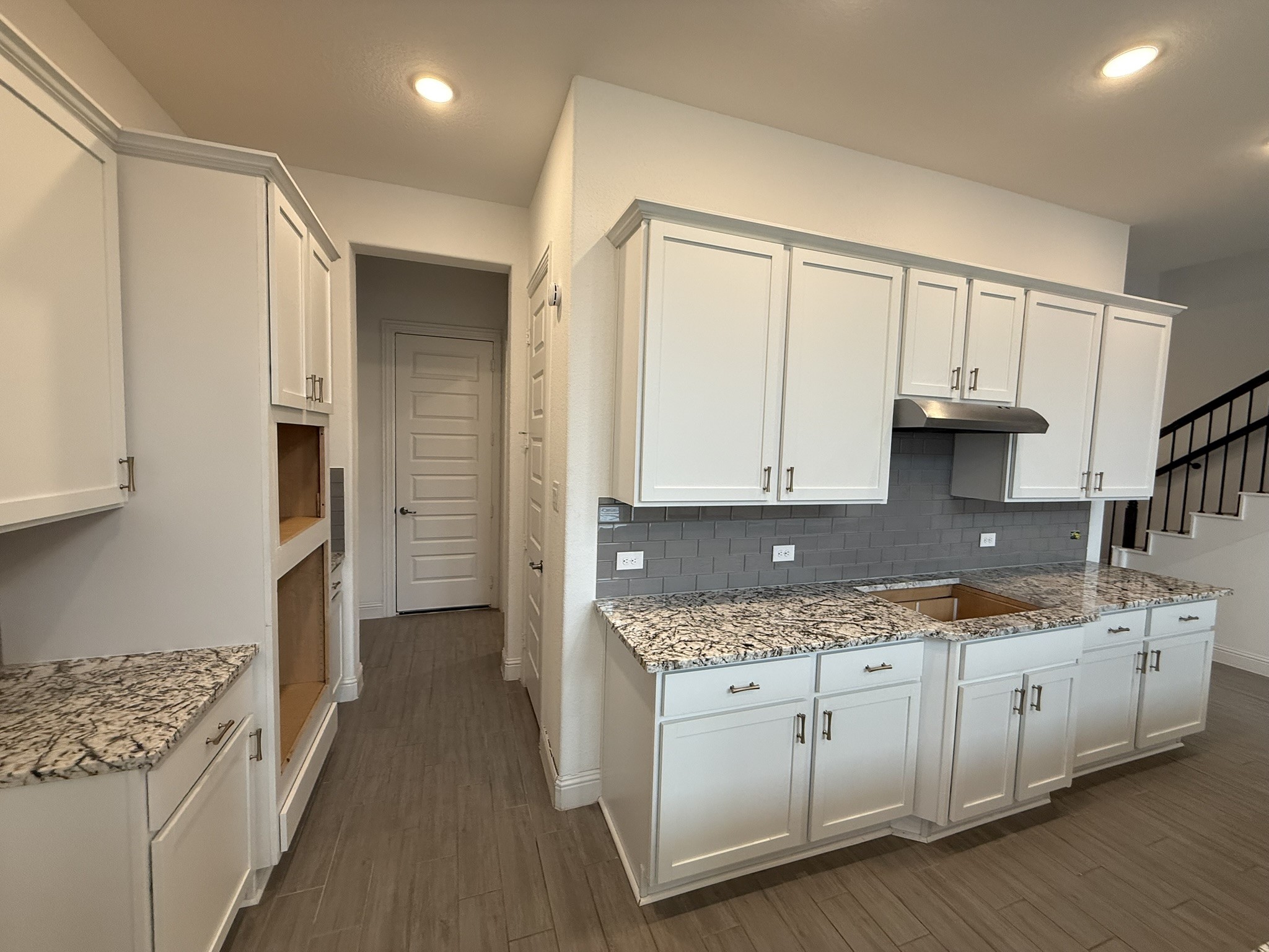 7802 Wayman Pass Fulshear, TX 77441 - Photo 12 of 50 a kitchen that has a lot of white cabinets and wooden floor