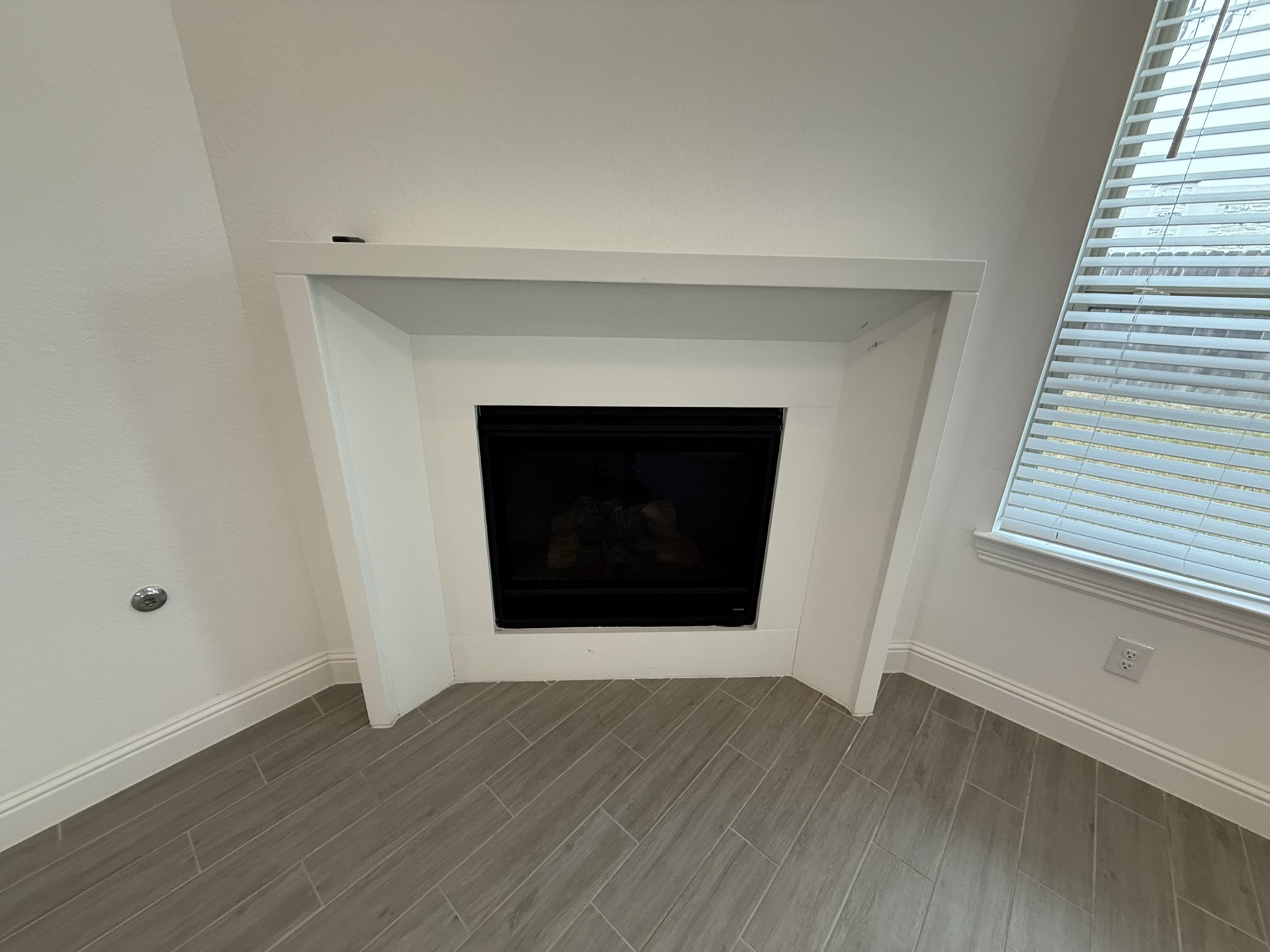 7802 Wayman Pass Fulshear, TX 77441 - Photo 19 of 50 an empty room with wooden floor and fireplace