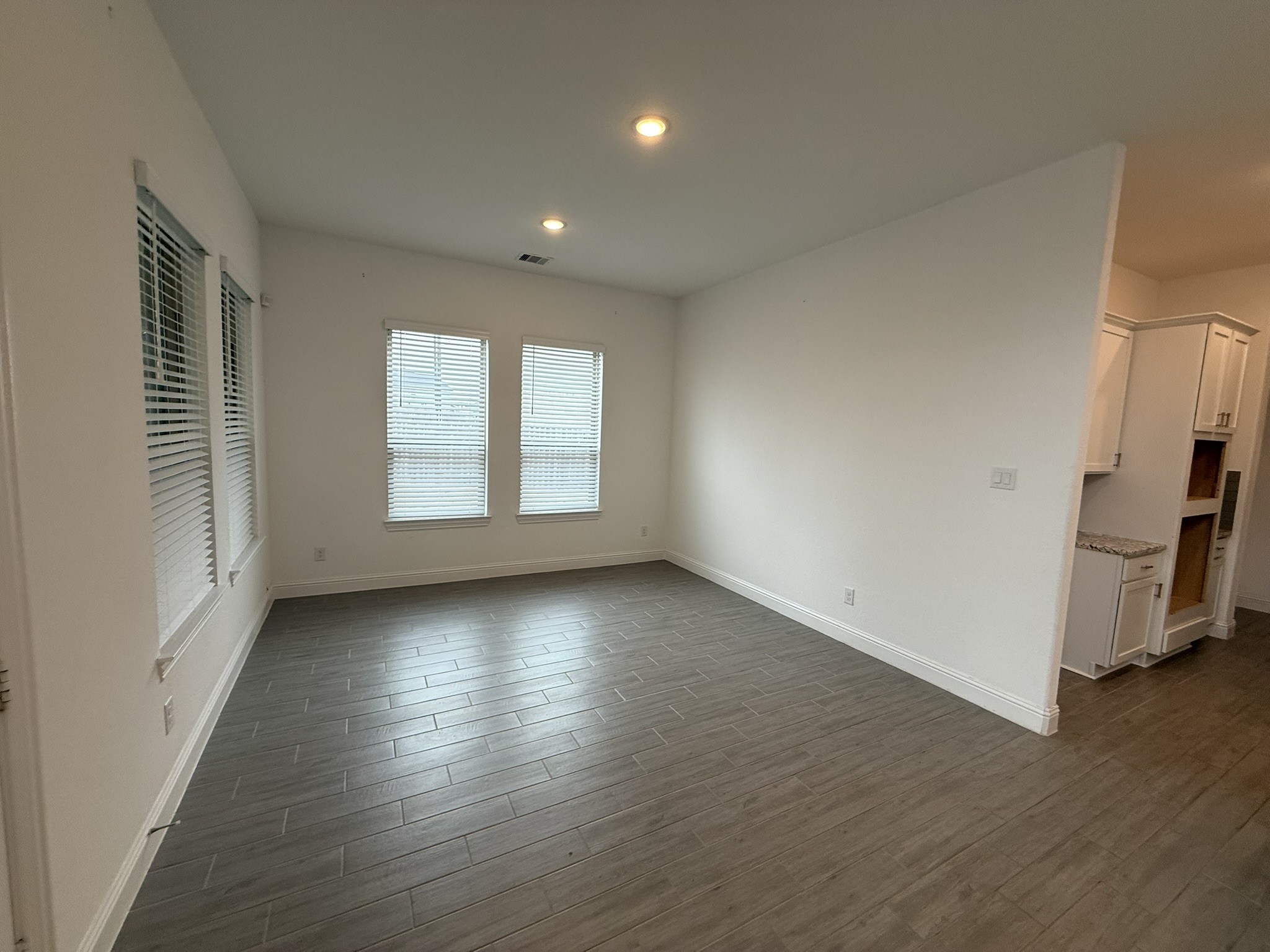 7802 Wayman Pass Fulshear, TX 77441 - Photo 20 of 50 an empty room with wooden floor and windows