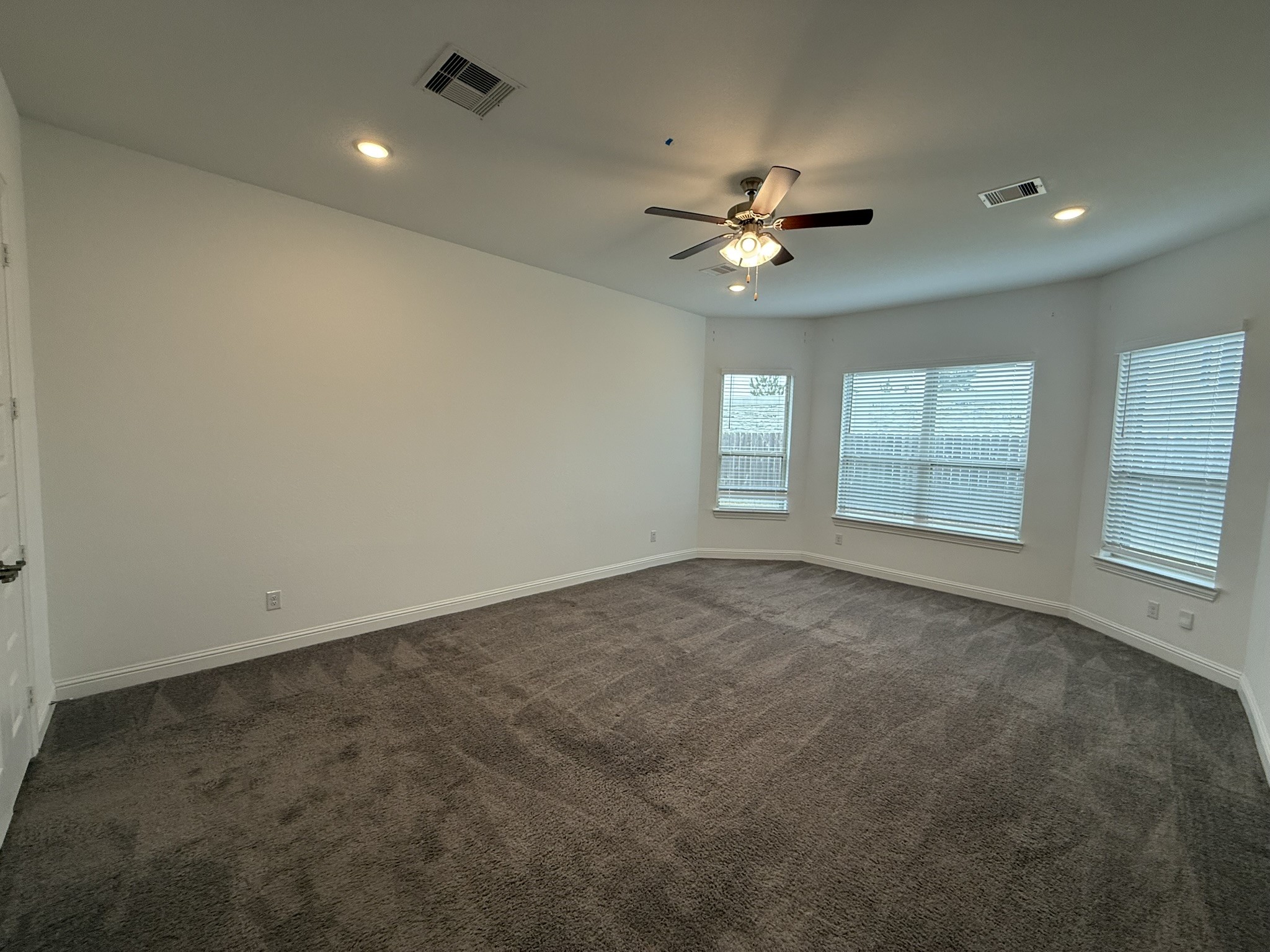 7802 Wayman Pass Fulshear, TX 77441 - Photo 25 of 50 an empty room with windows and ceiling fan