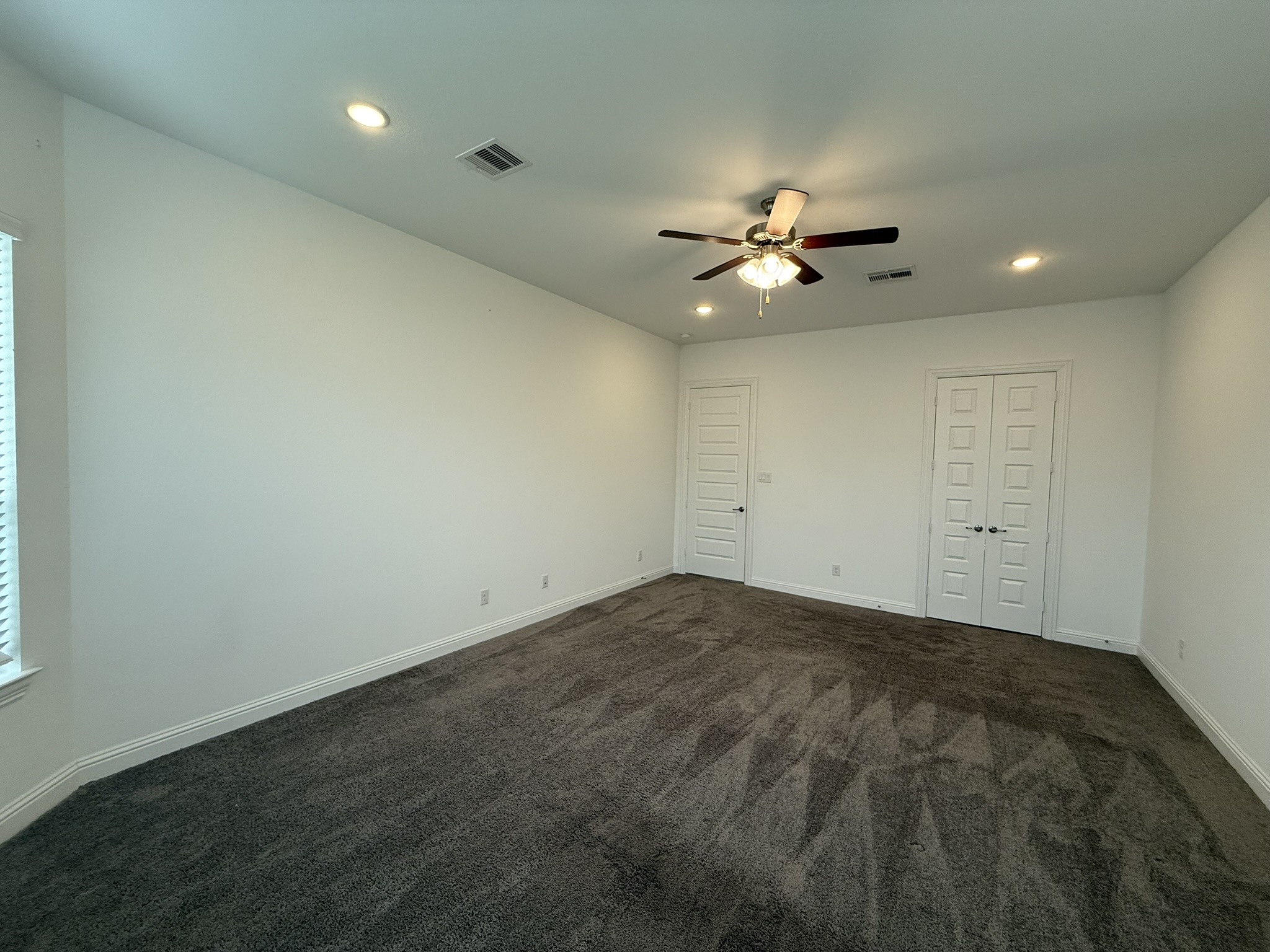 7802 Wayman Pass Fulshear, TX 77441 - Photo 27 of 50 an empty room with chandelier fan and window