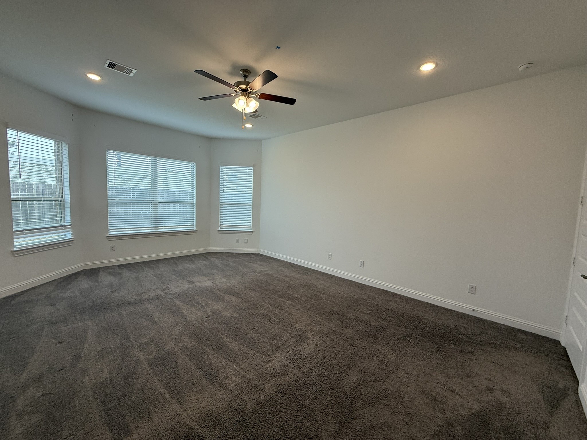 7802 Wayman Pass Fulshear, TX 77441 - Photo 28 of 50 an empty room with windows and fan