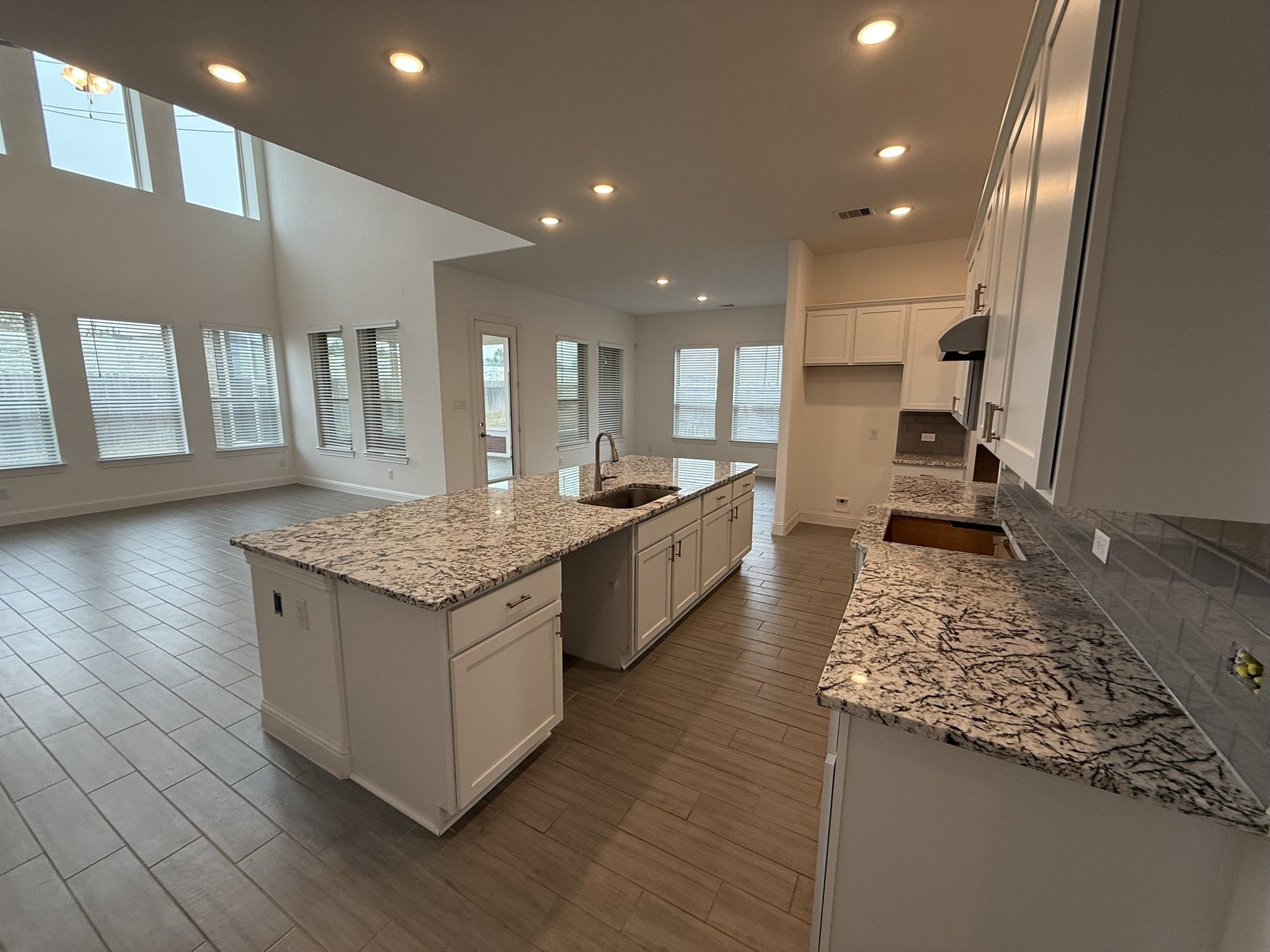7802 Wayman Pass Fulshear, TX 77441 - Photo 6 of 50 a large kitchen with granite countertop a large counter top and stainless steel appliances