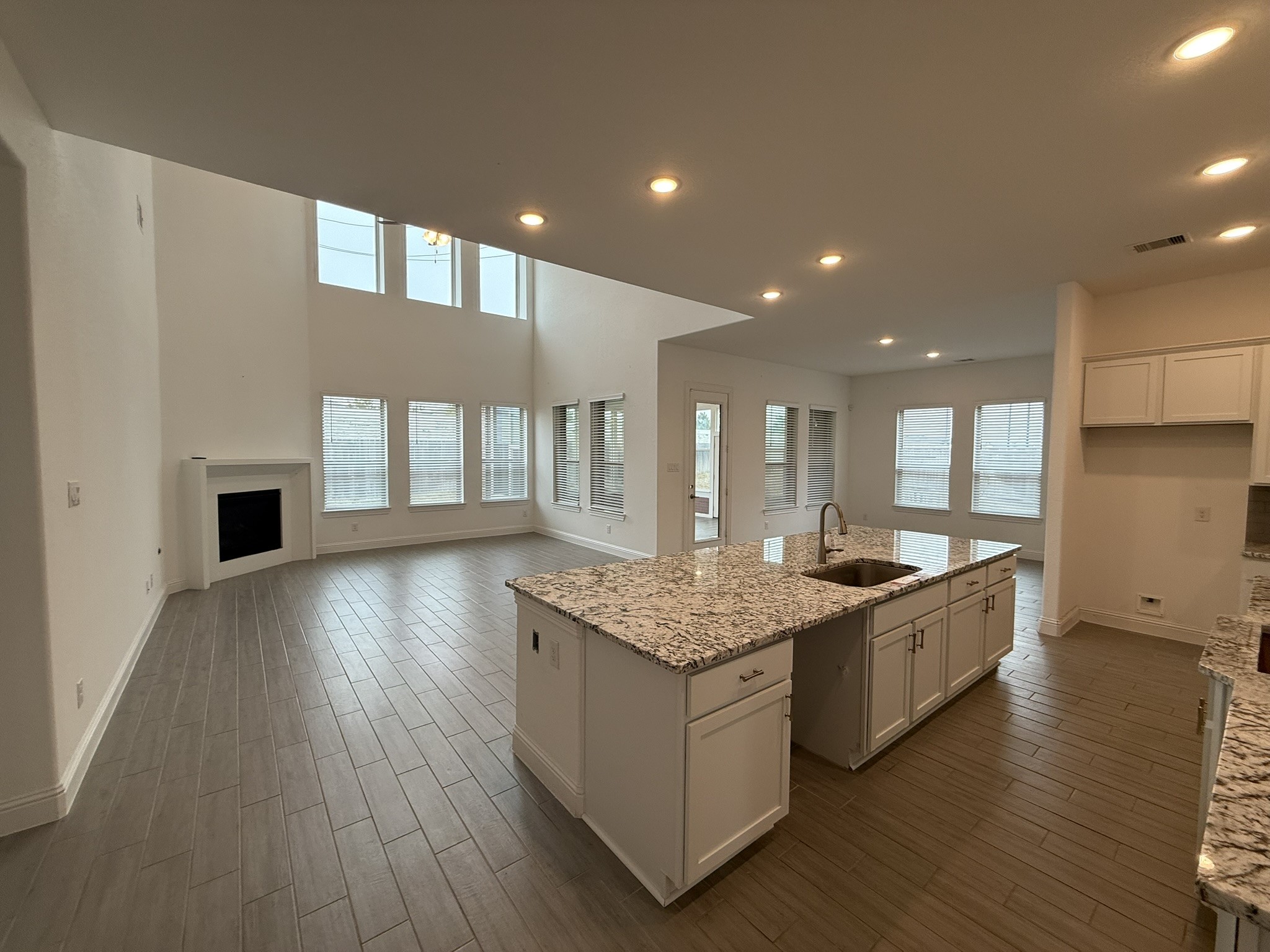 7802 Wayman Pass Fulshear, TX 77441 - Photo 7 of 50 a large kitchen with stainless steel appliances granite countertop a large counter top and a wooden floors