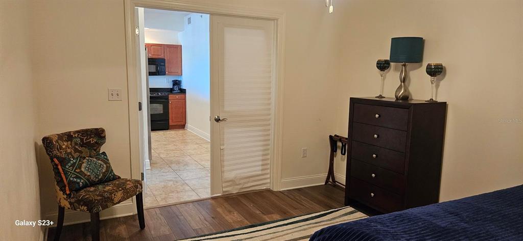 628 Cleveland Street, Unit 1207 Clearwater, FL 33755 - Photo 23 of 36 a bedroom with a bed and wooden floor