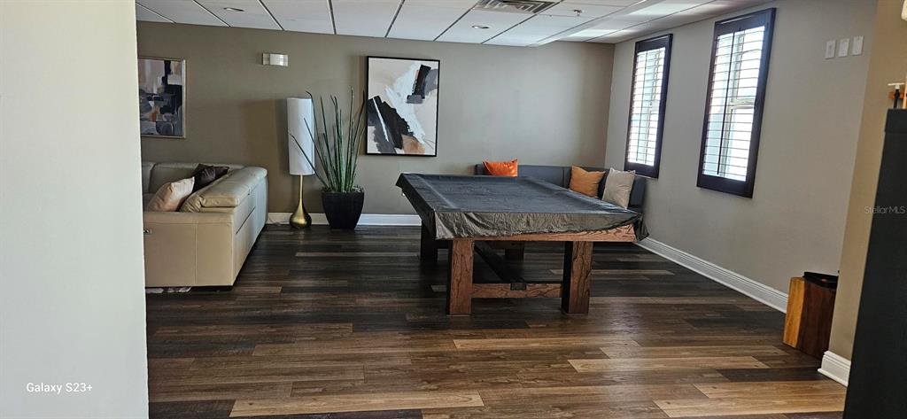 628 Cleveland Street, Unit 1207 Clearwater, FL 33755 - Photo 35 of 36 a dining room with wooden floor a glass table and chairs