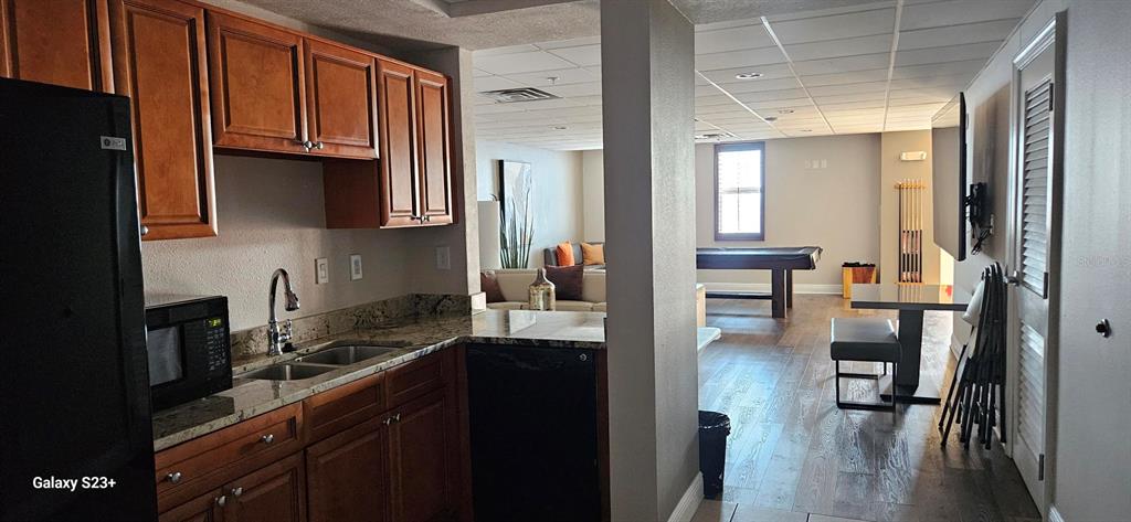 628 Cleveland Street, Unit 1207 Clearwater, FL 33755 - Photo 36 of 36 a kitchen with wooden cabinets and a refrigerator