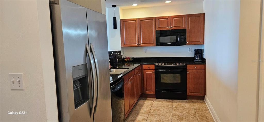628 Cleveland Street, Unit 1207 Clearwater, FL 33755 - Photo 6 of 36 a kitchen with a refrigerator and a microwave