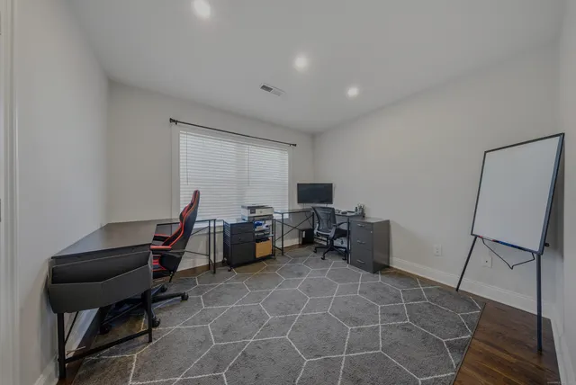 a view of a workspace with furniture and a window