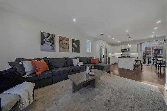 a living room with furniture and view of kitchen