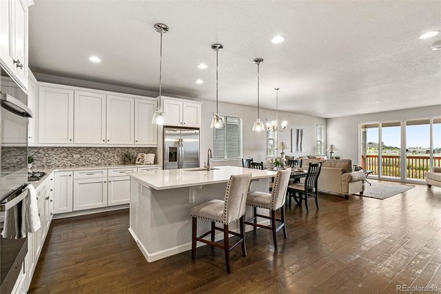 a large white kitchen with lots of counter space and dining table