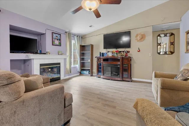 a living room with furniture a flat screen tv and a fireplace