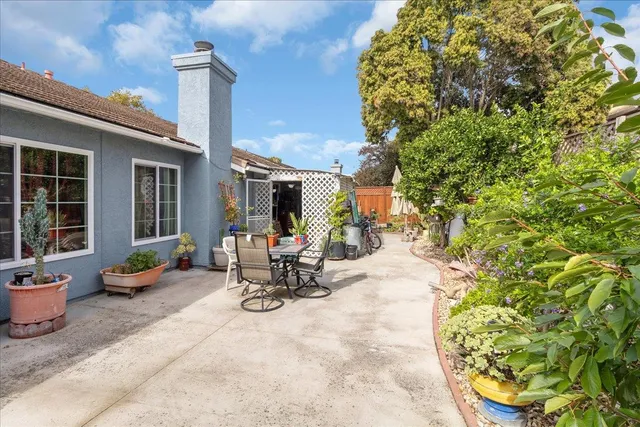 a view of a patio with a table and chairs and potted plants
